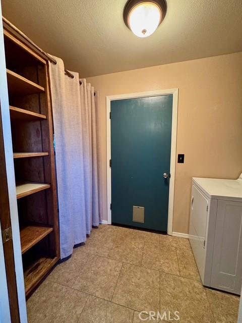 3646 Kirkwood Rd, Corning, CA 96021 - washroom featuring washer / clothes dryer and light tile patterned floors