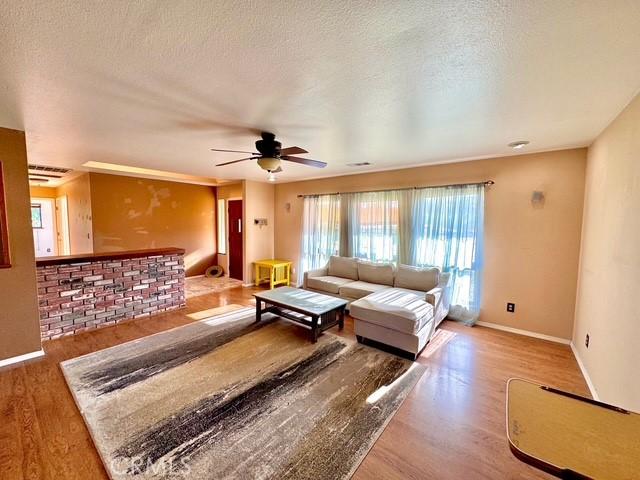3646 Kirkwood Rd, Corning, CA 96021 - living area with wood finished floors, a ceiling fan, and a textured ceiling