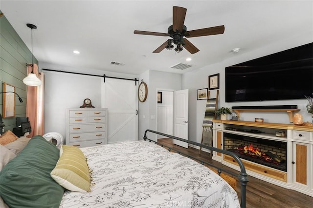 32954 Marin Fields Rd, Winchester, CA 92596 - bedroom with a barn door, wood finished floors, recessed lighting, a lit fireplace, and ceiling fan