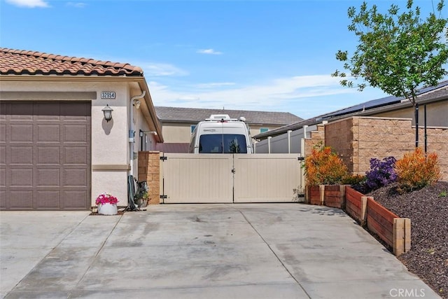 32954 Marin Fields Rd, Winchester, CA 92596 - view of side of property featuring a gate, concrete driveway, stucco siding, and a garage