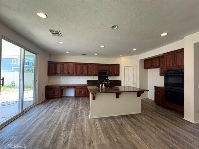 2306 Camellia St, Palmdale, CA 93551 - kitchen featuring stainless steel microwave, dark countertops, dark wood-style flooring, a sink, and recessed lighting
