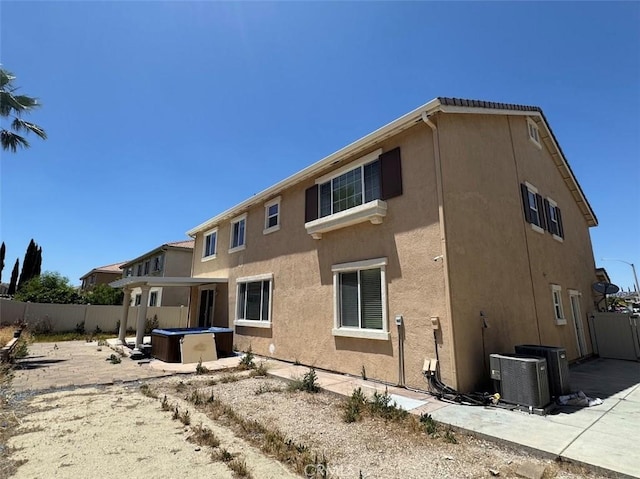 2306 Camellia St, Palmdale, CA 93551 - rear view of property with a hot tub, stucco siding, and central AC unit