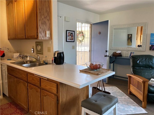 525 Grande Ave Unit D, Nipomo, CA 93444 - kitchen with a sink, a breakfast bar, brown cabinets, light countertops, and a peninsula