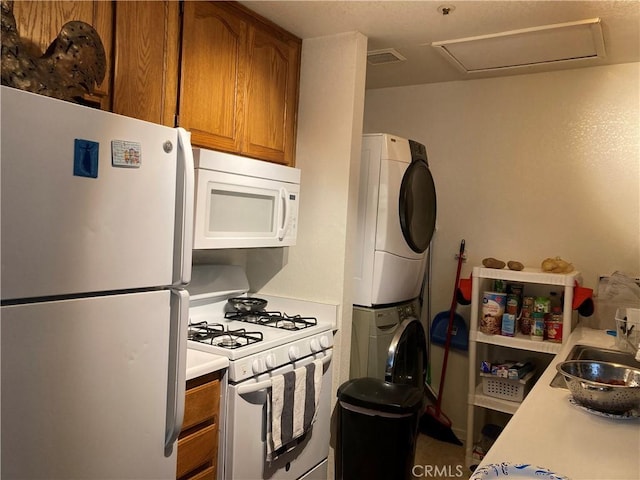 525 Grande Ave Unit D, Nipomo, CA 93444 - kitchen with white appliances, stacked washer / dryer, brown cabinets, and light countertops