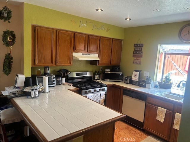116 Evergreen Pl, Perris, CA 92571 - kitchen with stainless steel appliances, tile countertops, under cabinet range hood, brown cabinets, and a peninsula