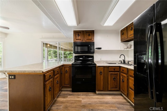 5048 Big Bend Rd, Oroville, CA 95965 - kitchen featuring black appliances, a sink, a peninsula, light wood-style flooring, and light countertops