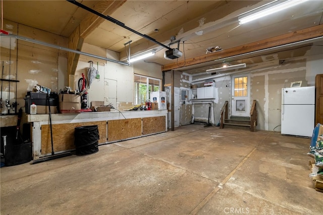 5048 Big Bend Rd, Oroville, CA 95965 - garage featuring freestanding refrigerator, a garage door opener, and a workshop area