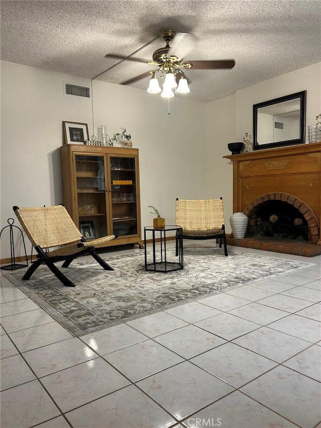 2035 N Spruce Ave, Rialto, CA 92377 - sitting room featuring ceiling fan, a brick fireplace, a textured ceiling, and tile patterned flooring