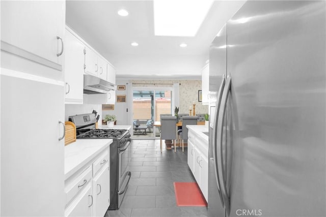 8381 E Hendrie St, Long Beach, CA 90808 - kitchen featuring appliances with stainless steel finishes, under cabinet range hood, white cabinetry, recessed lighting, and dark tile patterned floors