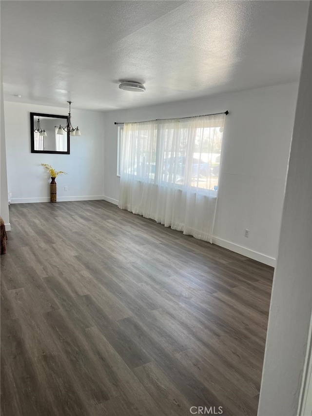 38565 Malby Ave, Palmdale, CA 93550 - unfurnished room with baseboards, a chandelier, dark wood-type flooring, and a textured ceiling