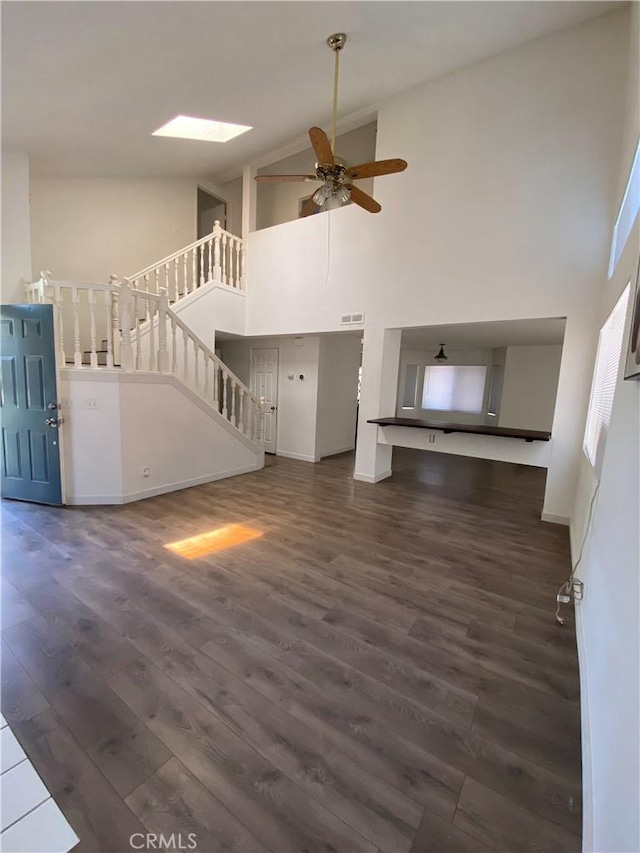 43321 Cottage Ln, Lancaster, CA 93536 - unfurnished living room with high vaulted ceiling, stairs, dark wood finished floors, a ceiling fan, and baseboards