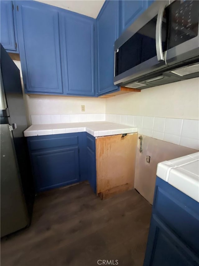 43321 Cottage Ln, Lancaster, CA 93536 - kitchen with blue cabinetry, appliances with stainless steel finishes, dark wood-type flooring, and light countertops