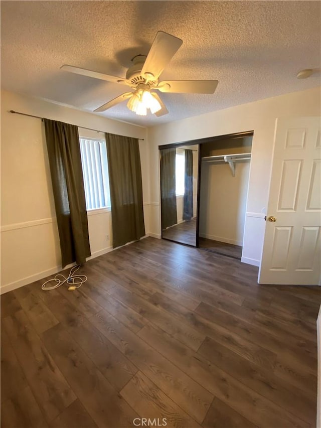 43321 Cottage Ln, Lancaster, CA 93536 - unfurnished bedroom featuring a textured ceiling, dark wood finished floors, a closet, baseboards, and a ceiling fan