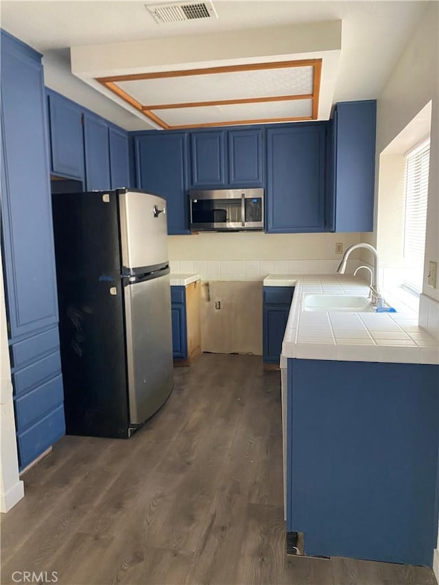43321 Cottage Ln, Lancaster, CA 93536 - kitchen featuring stainless steel appliances, blue cabinets, and dark wood-type flooring