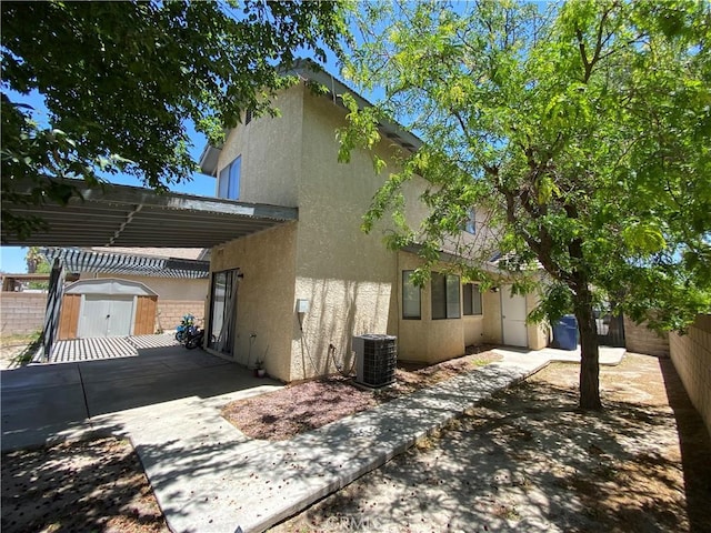 43321 Cottage Ln, Lancaster, CA 93536 - view of side of property with stucco siding, a fenced backyard, and a shed