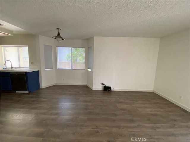 43321 Cottage Ln, Lancaster, CA 93536 - unfurnished living room featuring dark wood-style flooring and a textured ceiling