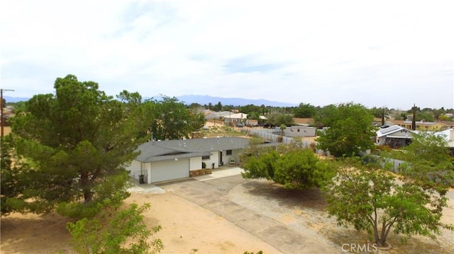 21161 Rancherias Rd, Apple Valley, CA 92307 - view of front facade with concrete driveway, an attached garage, and a residential view
