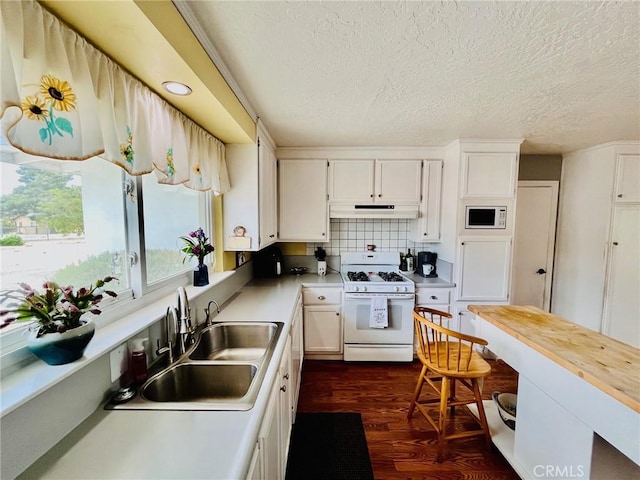 21161 Rancherias Rd, Apple Valley, CA 92307 - kitchen with white appliances, under cabinet range hood, a textured ceiling, dark wood finished floors, and white cabinets