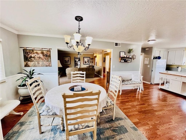 21161 Rancherias Rd, Apple Valley, CA 92307 - dining room with a chandelier, wood finished floors, ornamental molding, and a textured ceiling