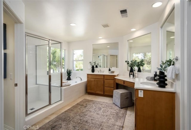 44035 Cindy Cir, Temecula, CA 92592 - bathroom featuring two vanities, a shower stall, a bath, plenty of natural light, and recessed lighting