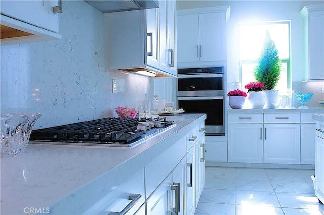 11986 Sagecrest Ct, Corona, CA 92883 - kitchen with appliances with stainless steel finishes, white cabinetry, light marble finish floors, custom exhaust hood, and light stone counters