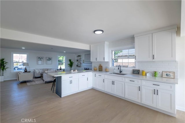 1748 Prince Albert Dr, Riverside, CA 92507 - kitchen with a sink, open floor plan, white cabinets, light wood-type flooring, and a peninsula