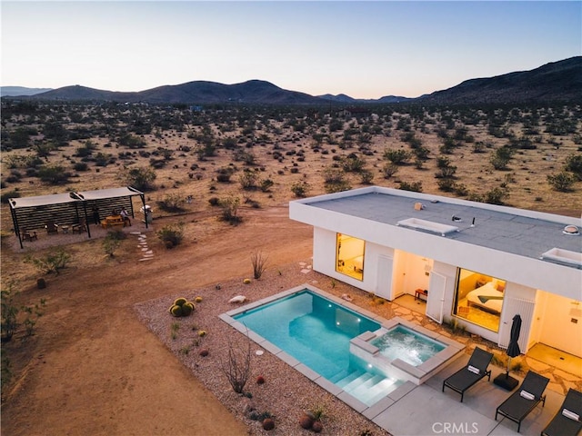 2600 Sunny Vista Rd, Joshua Tree, CA 92252 - pool at dusk featuring a mountain view, view of desert landscape, a pool with connected hot tub, and a patio