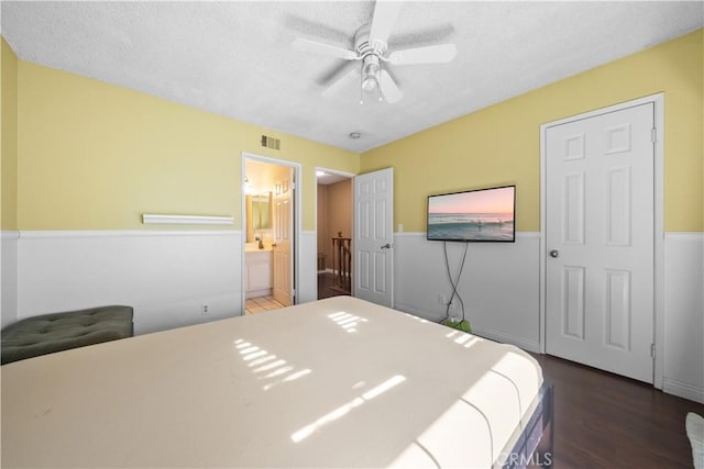 5640 Riverside Dr Unit 119, Chino, CA 91710 - bedroom with a textured ceiling, wood finished floors, wainscoting, ensuite bath, and ceiling fan