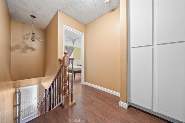 5640 Riverside Dr Unit 119, Chino, CA 91710 - corridor featuring a chandelier, an upstairs landing, wood finished floors, baseboards, and a textured ceiling