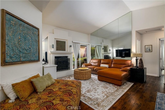 26629 Calle Gregorio, Menifee, CA 92585 - living room featuring a fireplace with raised hearth, lofted ceiling, dark wood-style floors, and baseboards