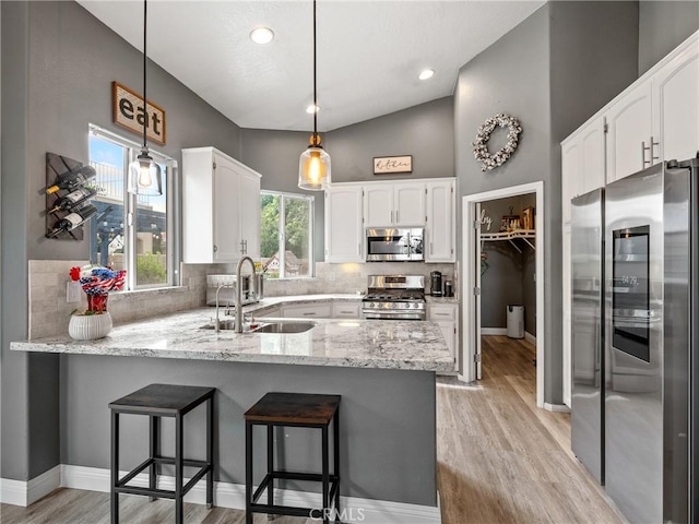 13290DR Country Club Dr, Victorville, CA 92395 - kitchen featuring stainless steel appliances, a sink, a peninsula, light wood-style flooring, and white cabinetry