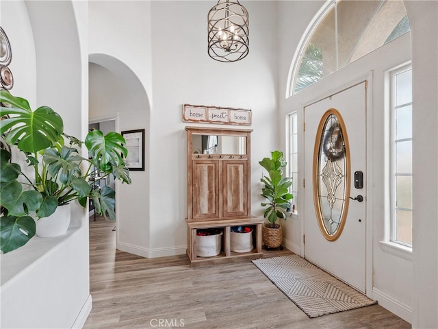 13290DR Country Club Dr, Victorville, CA 92395 - foyer entrance with light wood-type flooring, arched walkways, healthy amount of natural light, and a towering ceiling