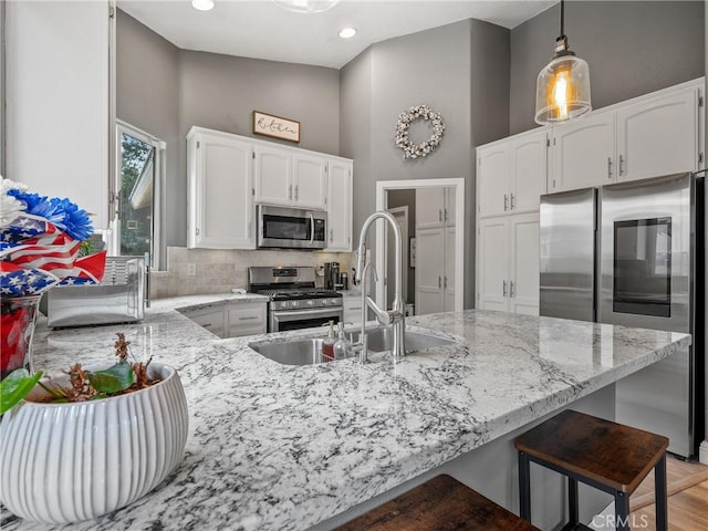 13290DR Country Club Dr, Victorville, CA 92395 - kitchen with stainless steel appliances, a peninsula, light stone countertops, white cabinetry, and recessed lighting