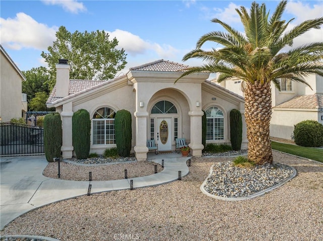 13290DR Country Club Dr, Victorville, CA 92395 - mediterranean / spanish-style home with a chimney, a tiled roof, stucco siding, and driveway