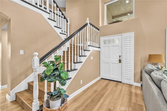21020 Bryan Cir, Walnut, CA 91789 - entryway with wood finished floors, stairway, a towering ceiling, and baseboards