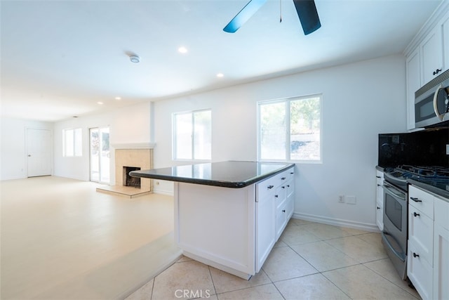 23125 Covello St, West Hills, CA 91307 - kitchen with appliances with stainless steel finishes, a ceiling fan, a tile fireplace, white cabinets, and recessed lighting