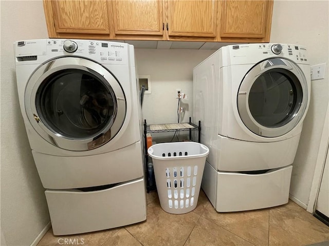 24967 Volga St, Hemet, CA 92544 - washroom featuring washer / dryer, cabinet space, and light tile patterned floors