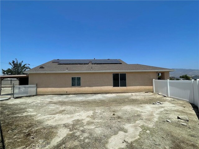 24967 Volga St, Hemet, CA 92544 - rear view of property with solar panels, a fenced backyard, stucco siding, and a shingled roof