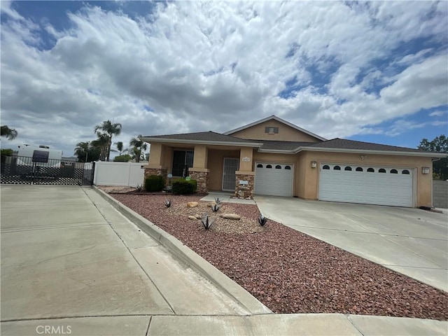 24967 Volga St, Hemet, CA 92544 - view of front facade with concrete driveway, stucco siding, a garage, and stone siding