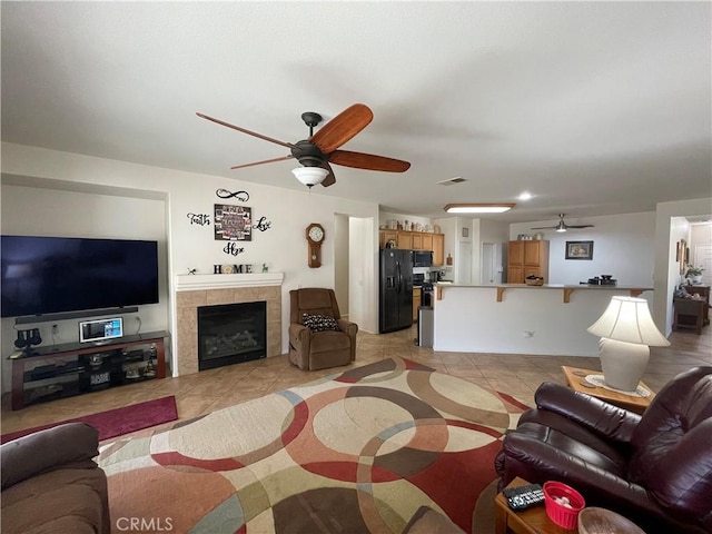 24967 Volga St, Hemet, CA 92544 - living room featuring ceiling fan, light tile patterned floors, and a tile fireplace