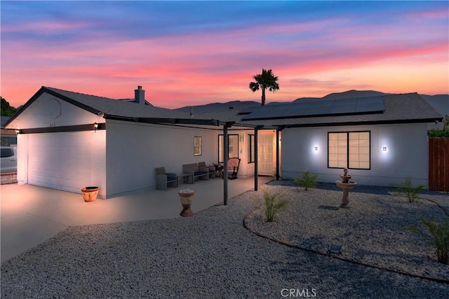 813 Yorkshire, San Jacinto, CA 92583 - back of house featuring roof mounted solar panels, a garage, concrete driveway, a patio area, and roof with shingles