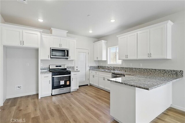 428 Oleander Ct, Chowchilla, CA 93610 - kitchen featuring stainless steel appliances, a sink, white cabinetry, light stone countertops, and recessed lighting
