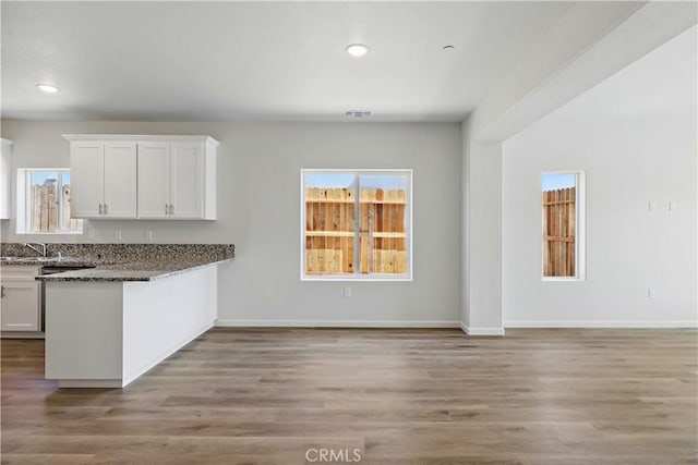 428 Oleander Ct, Chowchilla, CA 93610 - kitchen featuring white cabinetry, healthy amount of natural light, recessed lighting, and light wood-style flooring