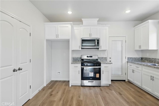 428 Oleander Ct, Chowchilla, CA 93610 - kitchen featuring stainless steel appliances, white cabinetry, light stone countertops, light wood finished floors, and recessed lighting