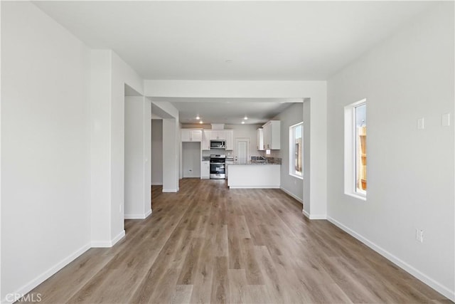 428 Oleander Ct, Chowchilla, CA 93610 - unfurnished living room with light wood-style flooring and baseboards