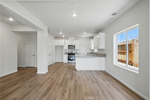 428 Oleander Ct, Chowchilla, CA 93610 - kitchen featuring appliances with stainless steel finishes, white cabinets, baseboards, light wood-style flooring, and recessed lighting