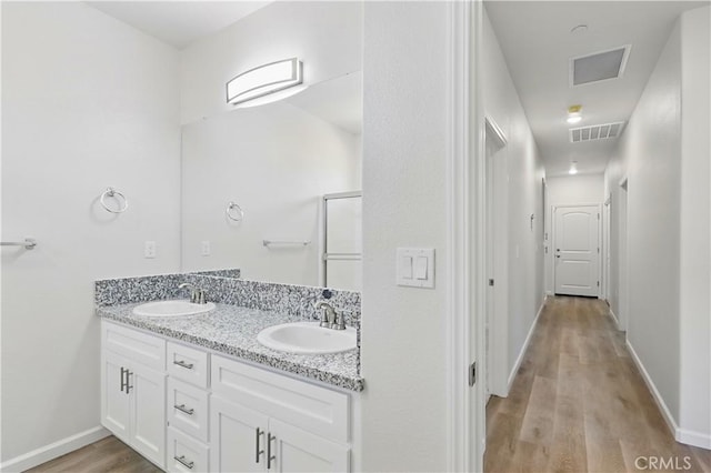 428 Oleander Ct, Chowchilla, CA 93610 - full bathroom featuring double vanity, wood finished floors, a shower with shower door, and baseboards