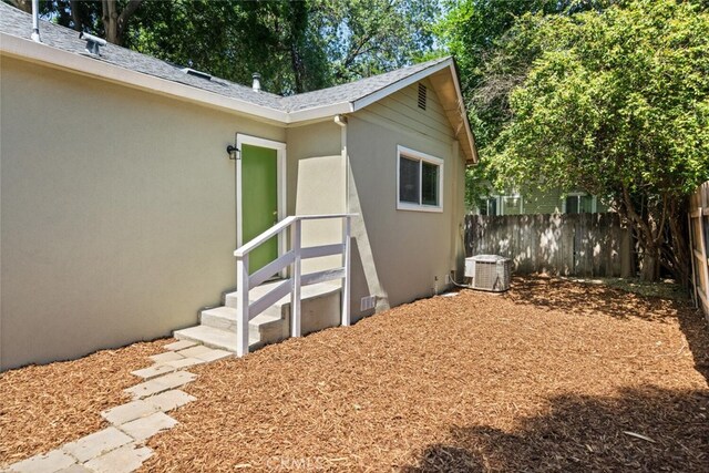 1170 Hobart St, Chico, CA 95926 - doorway to property featuring stucco siding, cooling unit, and a shingled roof
