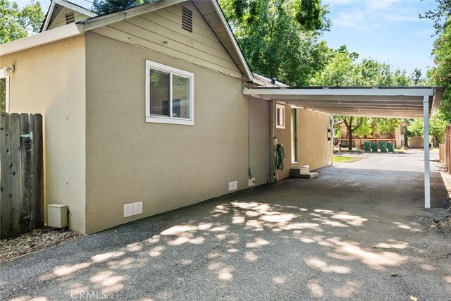 1170 Hobart St, Chico, CA 95926 - view of side of home with asphalt driveway, stucco siding, and a carport