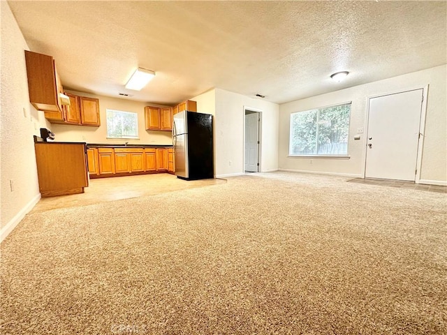 1170 Hobart St, Chico, CA 95926 - kitchen featuring freestanding refrigerator, a textured ceiling, brown cabinets, dark countertops, and open floor plan